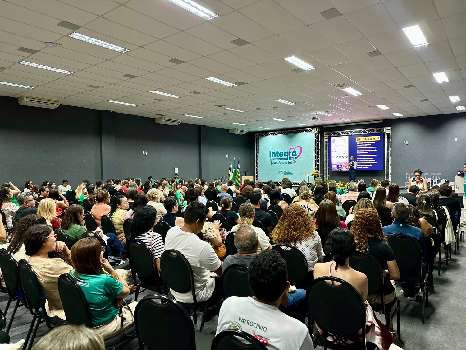 Evento educacional com professores assistindo palestra de Israel Elias